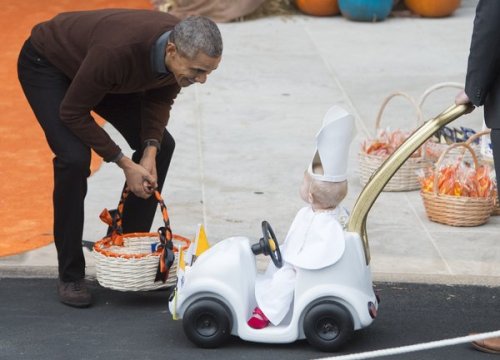 US President Barack Obama greets a young child dressed as the Pope and riding in a "Popemobile" as he hands out treats to children trick-or-treating for Halloween on the South Lawn of the White House in Washington, DC, October 30, 2015. AFP PHOTO / SAUL LOEB        (Photo credit should read SAUL LOEB/AFP/Getty Images)